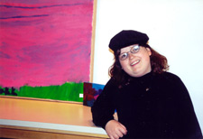 Eve standing next to her painting