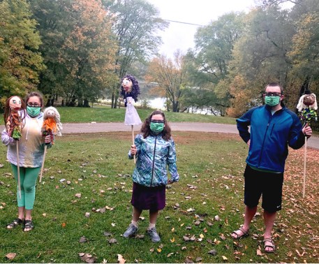 alt text= 3 people outside holding puppets